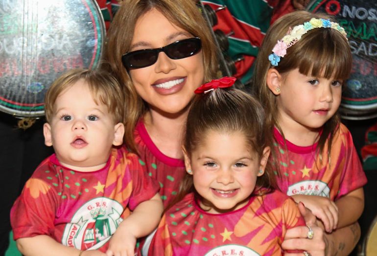 A influenciadora Virginia Fonseca posando com seus filhos Maria Alice, Maria Flor e José Leonardo na quadra da Grande Rio, todos usando a camisa da escola de samba para a festa de Dia das Crianças.